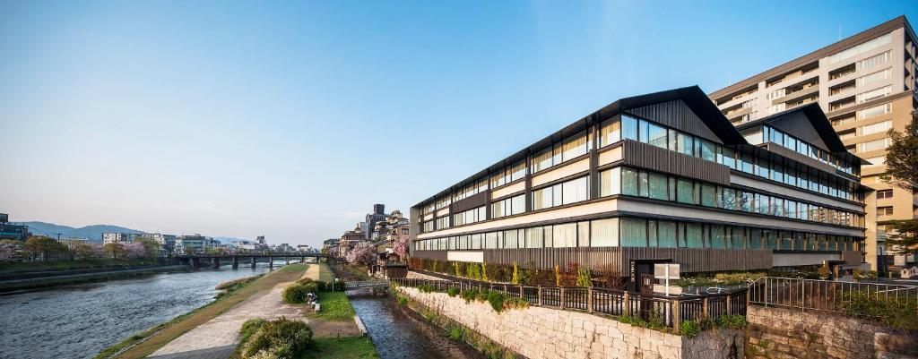 a building next to a river with buildings at Solaria Nishitetsu Hotel Kyoto Premier in Kyoto