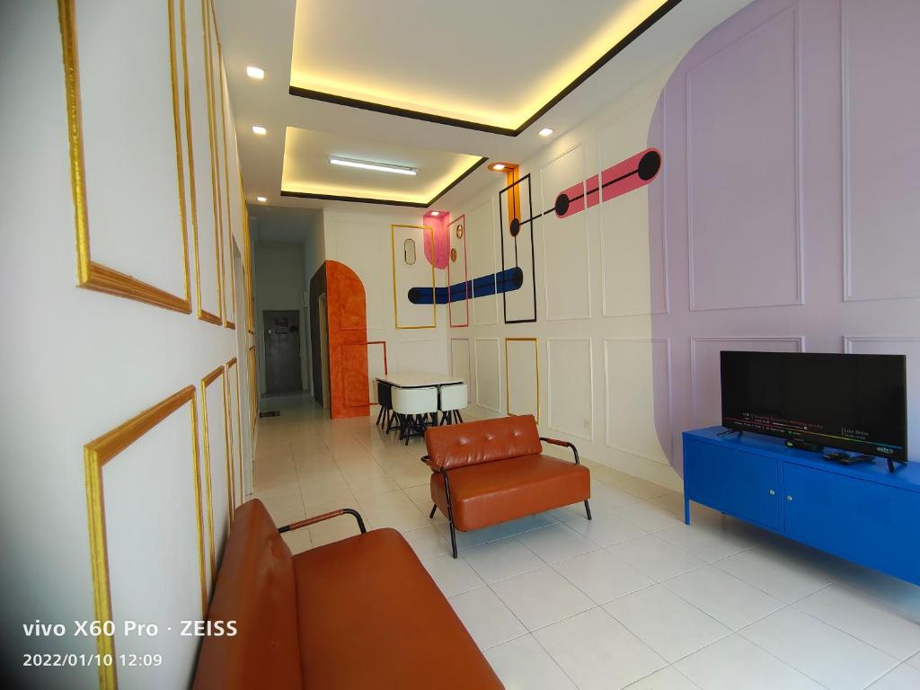 een kamer met een tv en een bank en een tafel bij CLASSIC ENGLISH @ CH in Tanah Rata