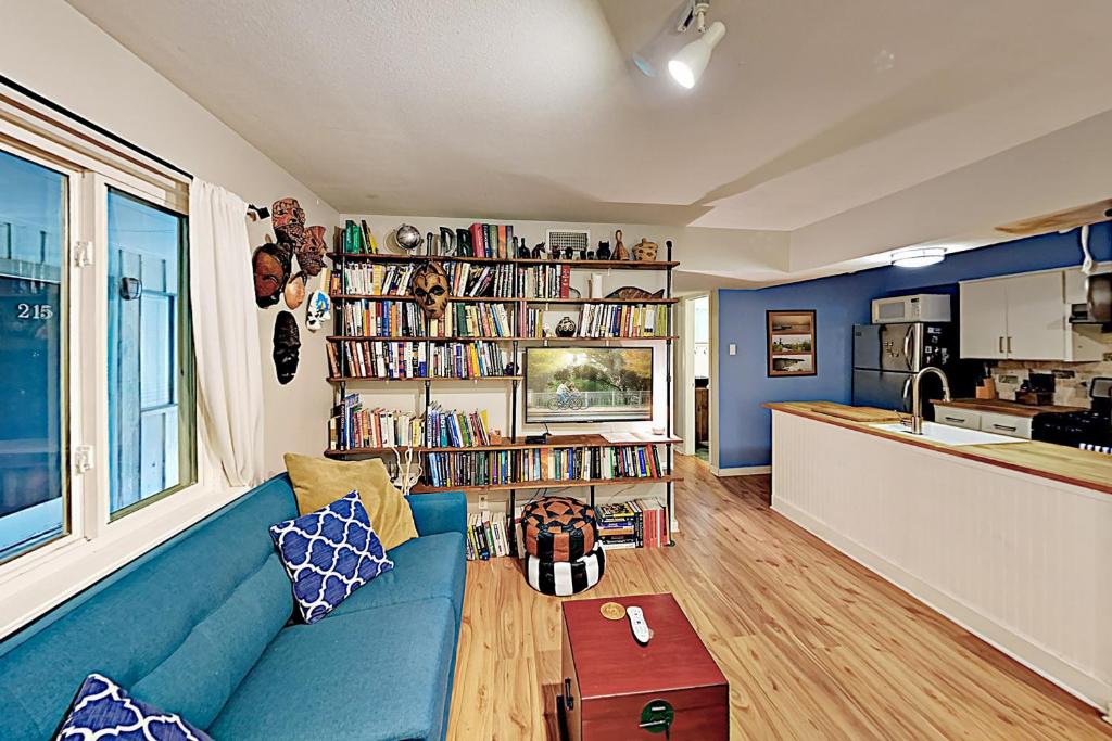 a living room with a blue couch and a kitchen at Creekside Terrace Condominiums #211 in Austin