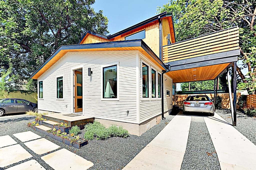 a small white house with a car parked in the driveway at Cozy Austin Hideaway in Austin