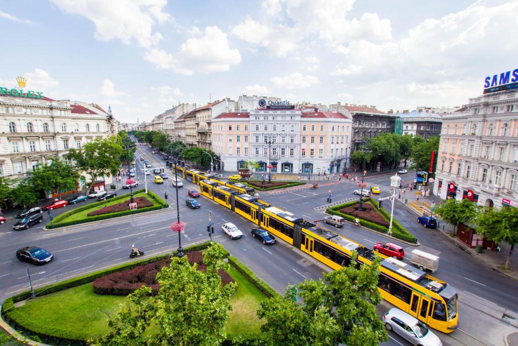 a city street with buses and cars in a city at Avenue Hostel in Budapest