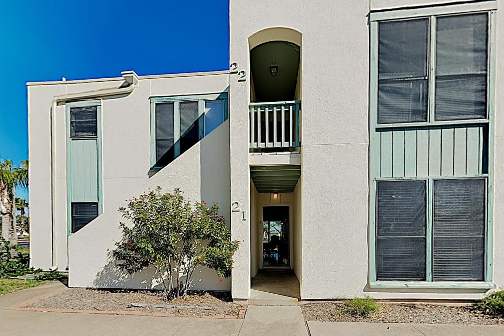 a white house with a staircase and a balcony at Fulton Beach Condos in Rockport