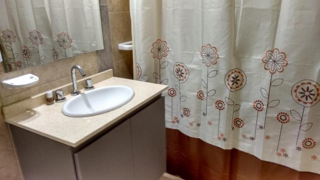 a bathroom with a sink and a shower curtain at Apartamento Esquiu C in Villa Carlos Paz