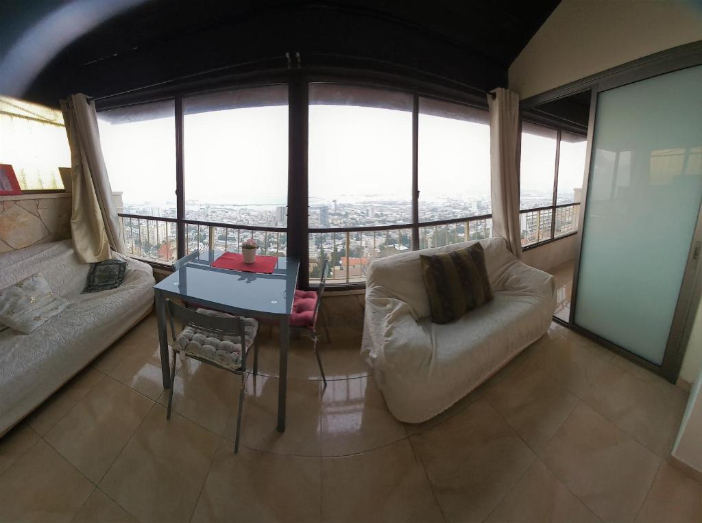 a living room with a couch and a table at Panorama Bay View 3 room in Haifa