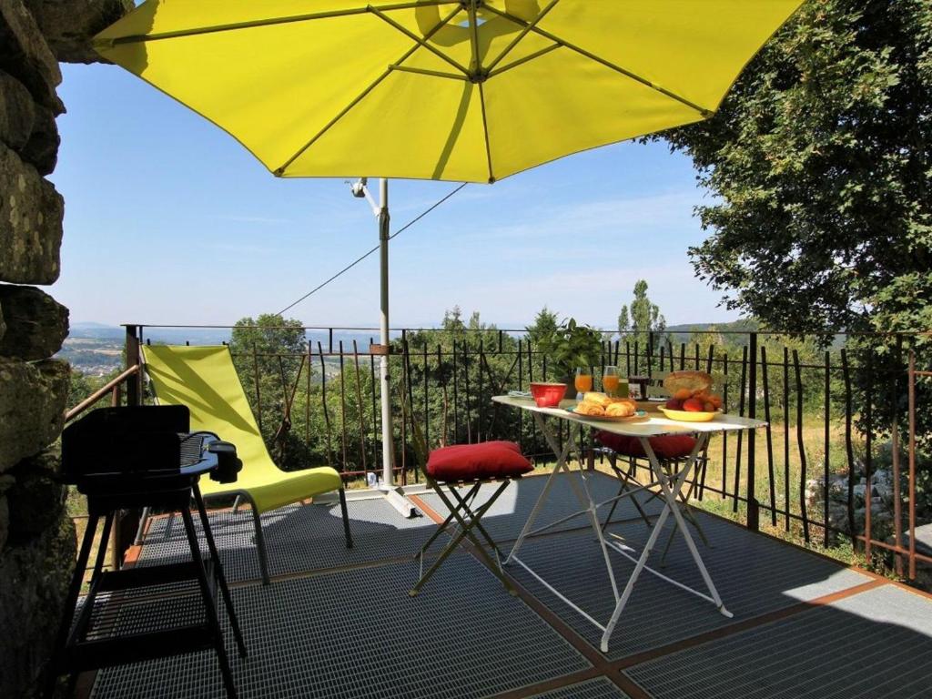 einen Tisch und Stühle mit Sonnenschirm auf dem Balkon in der Unterkunft Gîte Saint-Julien-Chapteuil, 2 pièces, 2 personnes - FR-1-582-29 in Saint-Julien-Chapteuil