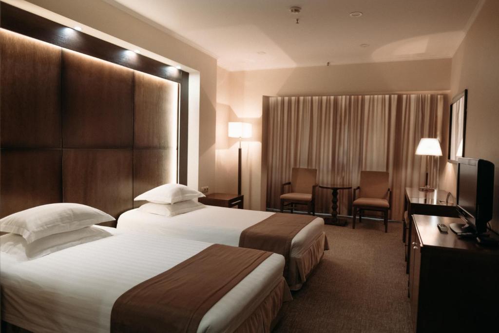 ウラン・ウデにあるホテル サガーン モリンのベッド2台とテレビが備わるホテルルームです。