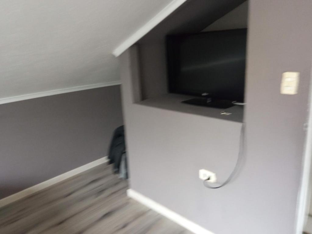 een kamer met een tv in de hoek van een kamer bij Los Arrayanes Hostel in Coquimbo
