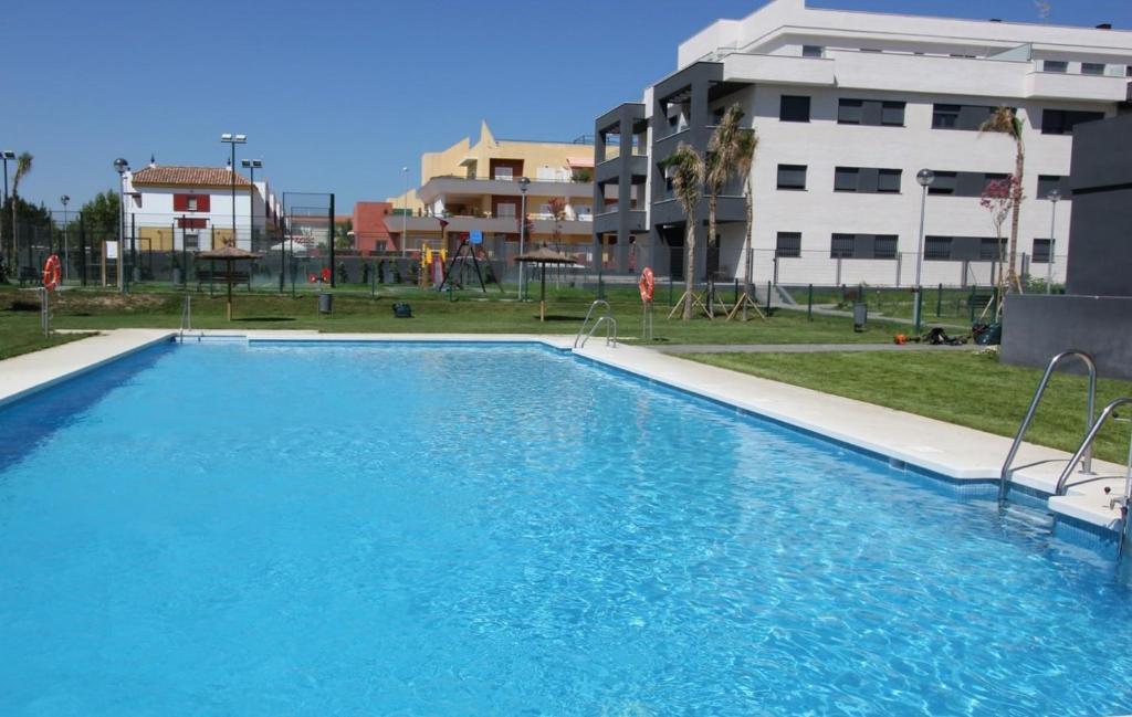 una gran piscina azul frente a un edificio en Felipe Frente al rio, en Sanlúcar de Barrameda