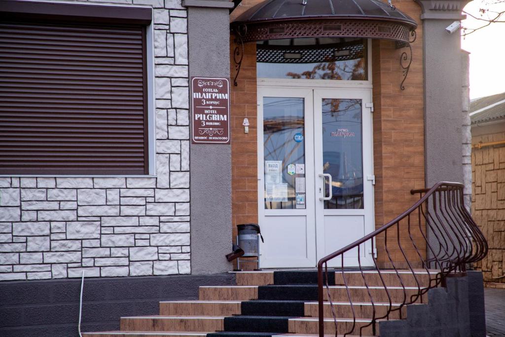 a building with a white door and stairs in front at Hotel Piligrim 3 in Mykolaiv