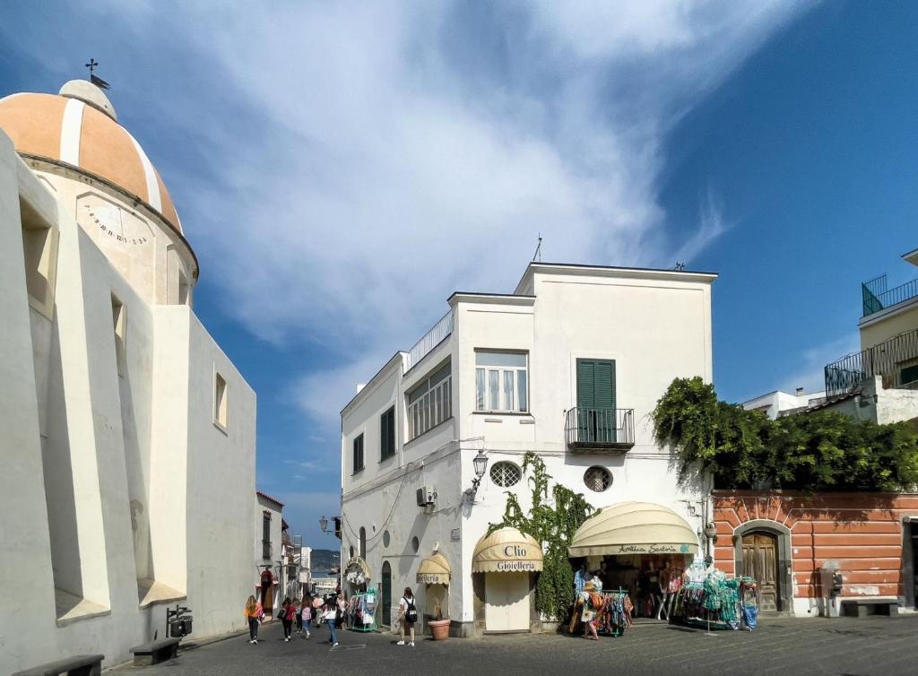 a white building with people walking in front of it at Sunlux Maison in Ischia