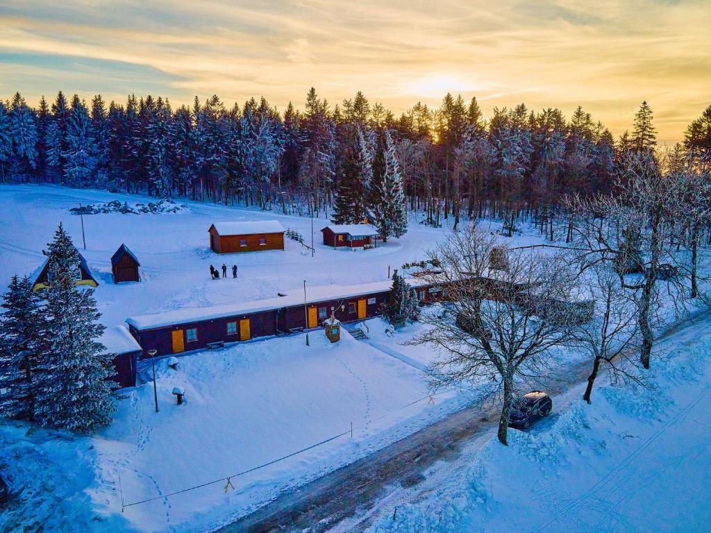 una casa en un campo cubierto de nieve con árboles en "Sporthütten Nassau" Ihr zentrales Domizil an der Blockline, en Bienenmühle