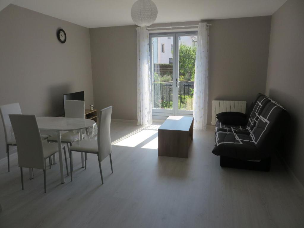 uma sala de estar com um sofá, uma mesa e cadeiras em Appartement 4 couchages em Clairvaux-les-Lacs