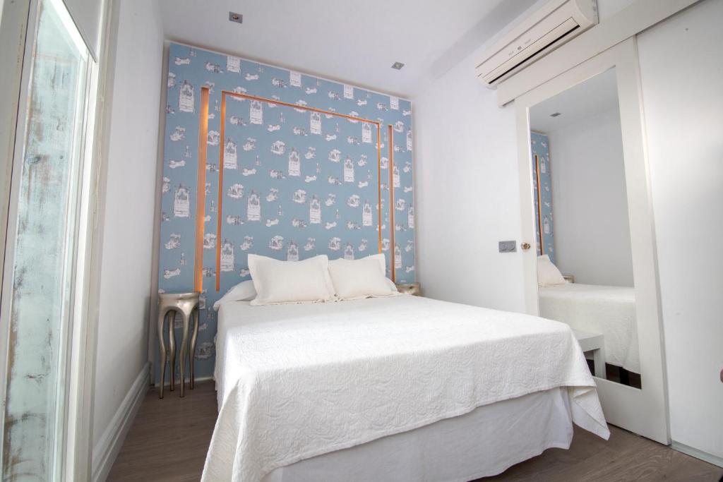 a bedroom with a bed with a blue wall at La Princesa y El Guisante in Conil de la Frontera