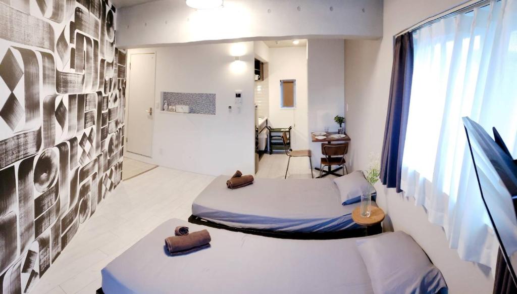 Habitación con 2 camas y mesa. en AOCA KAMINOGE 302, en Tokio