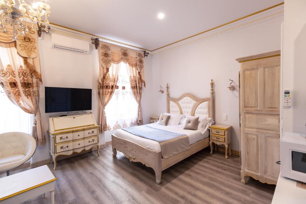 - une chambre avec un grand lit et une télévision dans l'établissement Studio du Maire Maison de L'Église du Couvent, à Narbonne