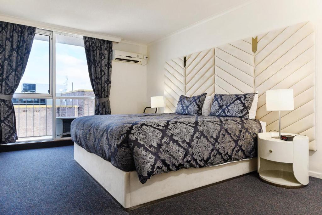a bedroom with a bed and a large window at Highpoint International Hotel in Gladstone