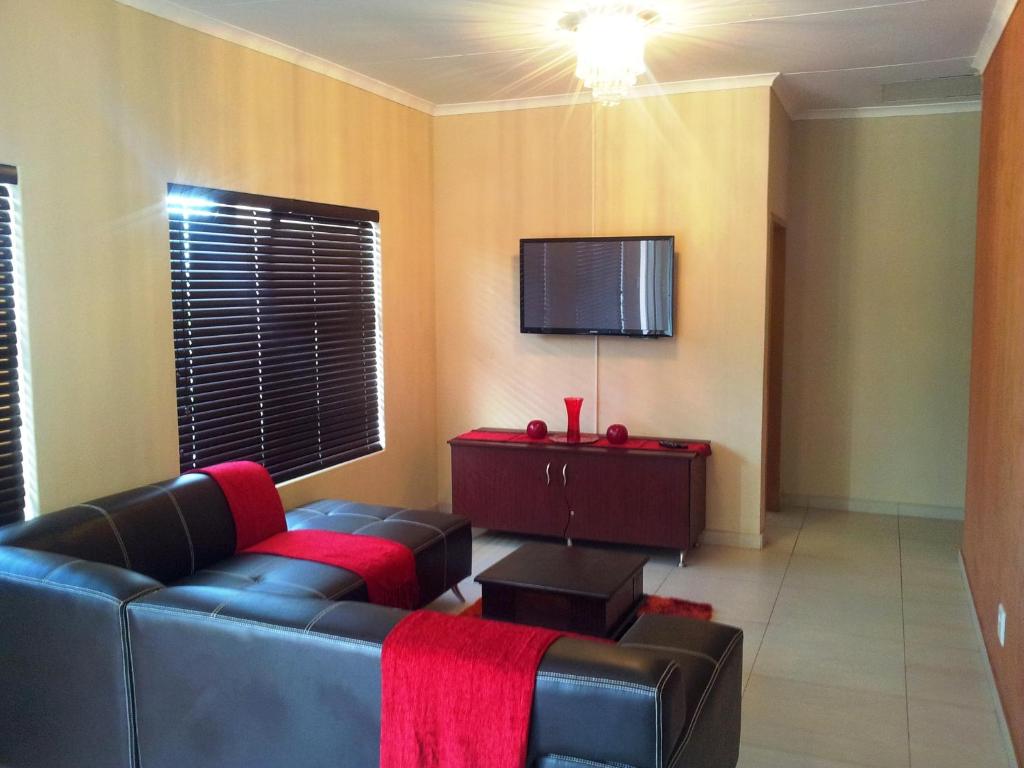 a living room with a couch and a flat screen tv at Parys In town Guest lodge and Conference Center in Parys