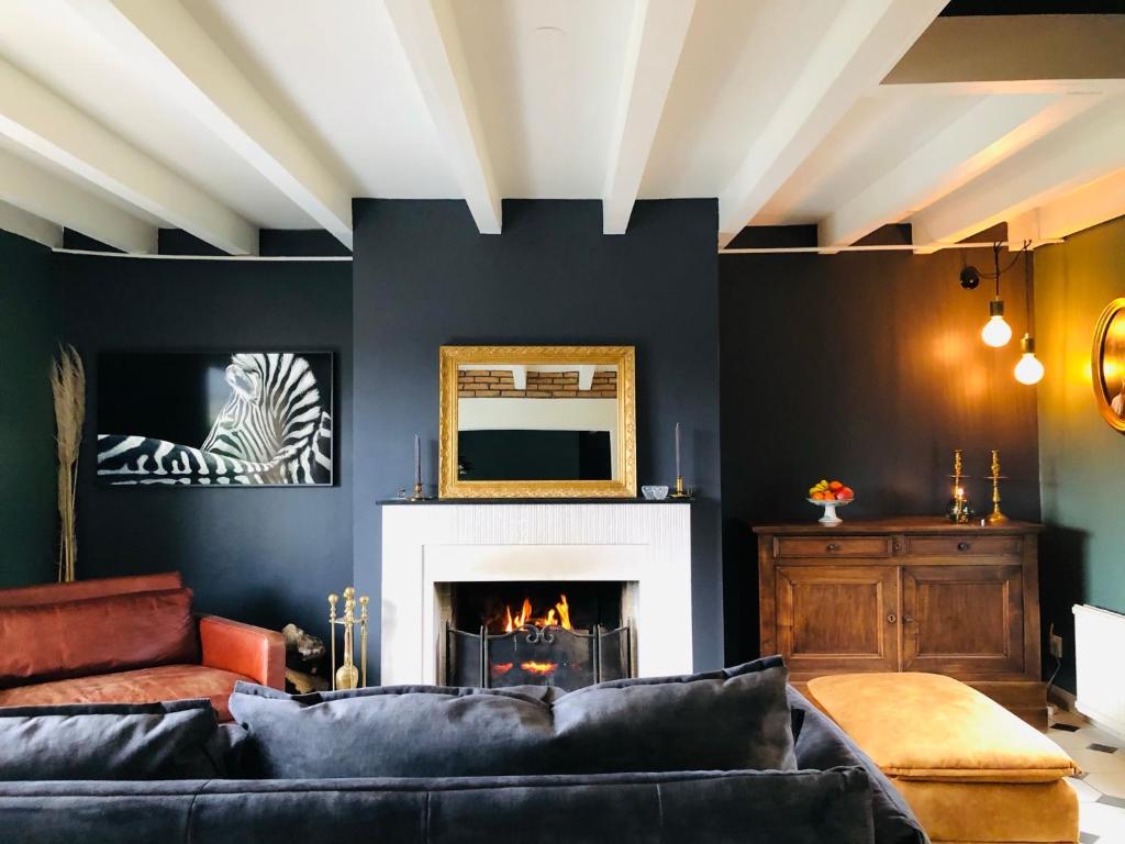 un salon avec un canapé et une cheminée dans l'établissement La maison, à Vittefleur