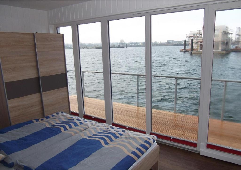 a bedroom with a view of the water from a boat at Schwimmendes Ferienhaus Swimming Lounge in Kappeln