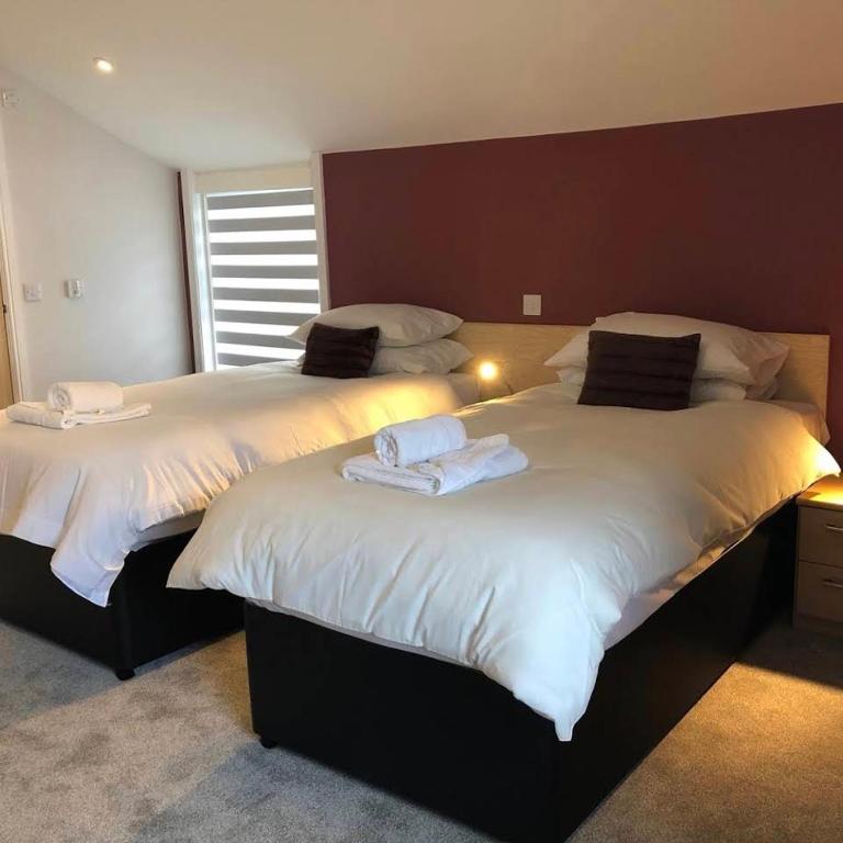 2 letti con asciugamani sopra in una camera da letto di Arrandale House a Douglas