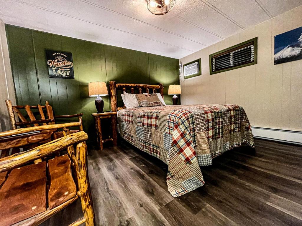 a bedroom with a bed and a green wall at Lone Fir Resort in Cougar
