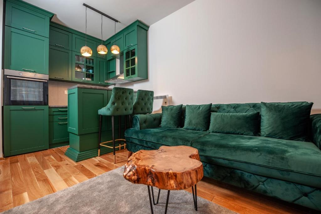 a living room with green cabinets and a green couch at Apartman Istra- Titova vila in Zlatibor