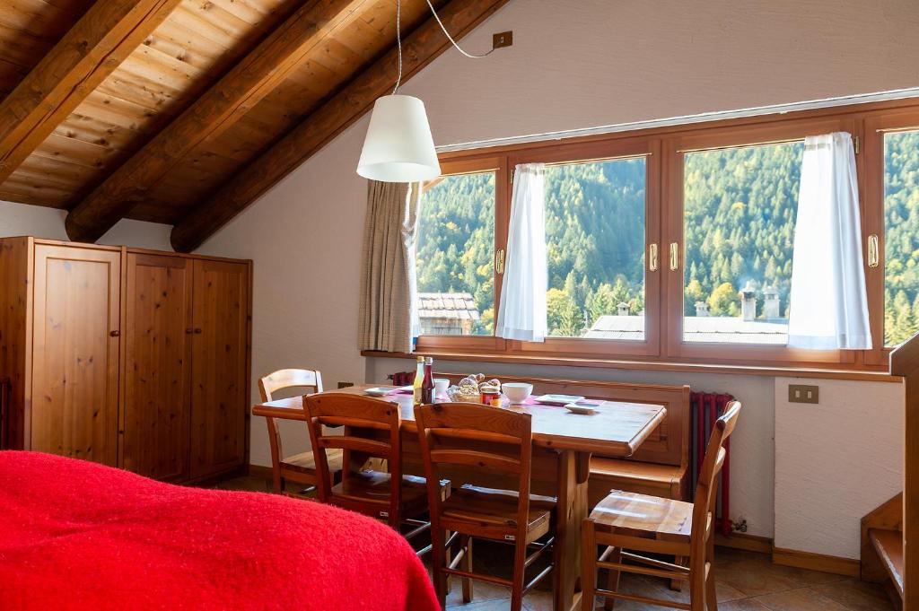 uma sala de jantar com uma mesa e cadeiras e uma janela em Residence Monterosa em Macugnaga
