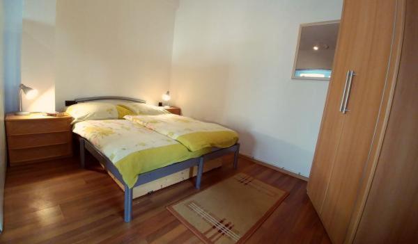 a bedroom with a bed and a wooden floor at Apartman Mijo 1 in Jadranovo