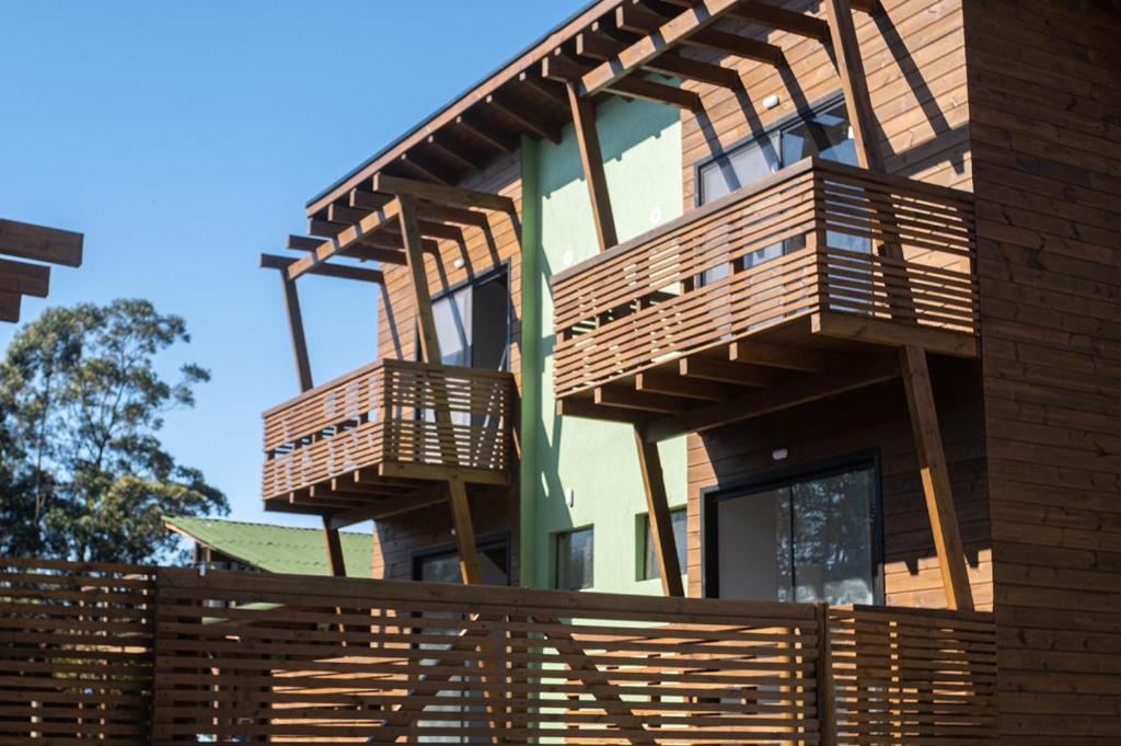 una casa con balcones de madera en un lateral en Local da Lagoa Chalés e Lofts en Imbituba