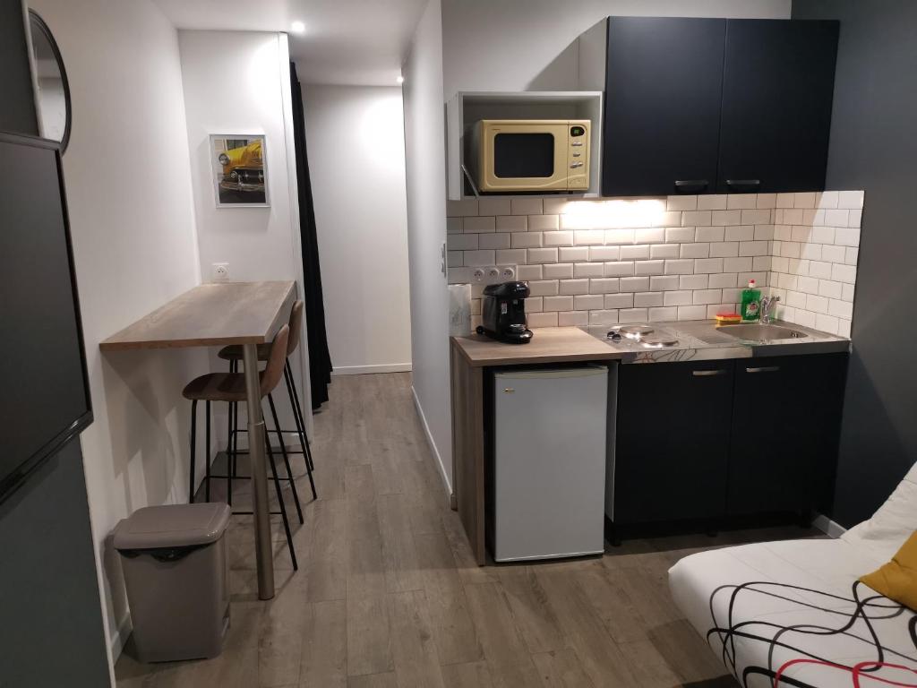 une petite cuisine avec un évier et un micro-ondes dans l'établissement Studio cosy au pied du METRO FLACHET, à Villeurbanne