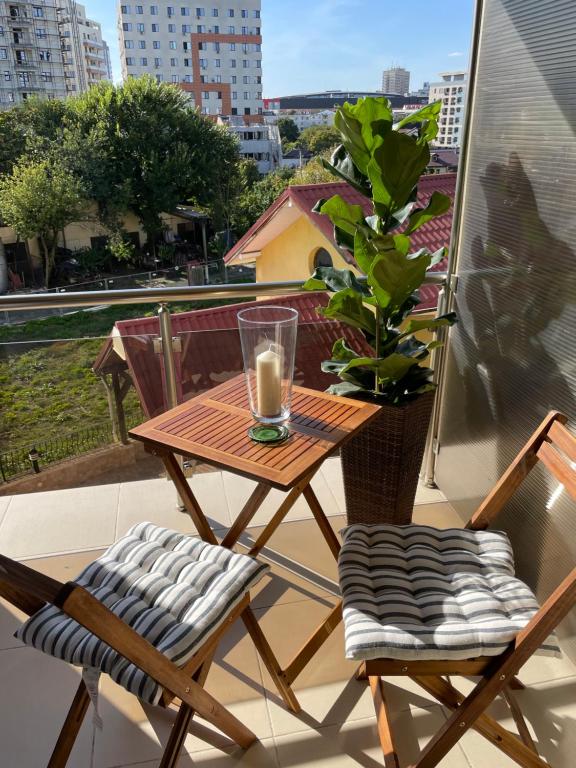 een tafel en twee stoelen op een balkon met een plant bij En Passant / a time in Iasi in Iaşi