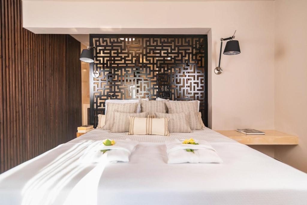 a bedroom with a large white bed with two towels at Archo Suites Pythagoreio in Pythagoreio