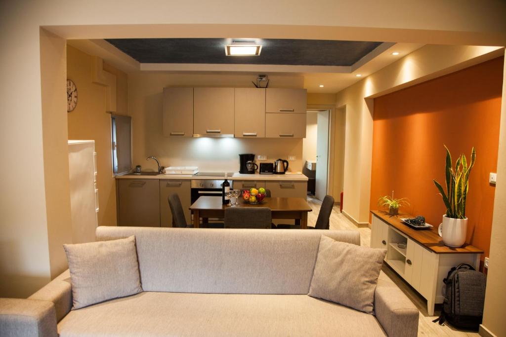 a living room with a couch and a kitchen at Paporas Apartments in Svoronata