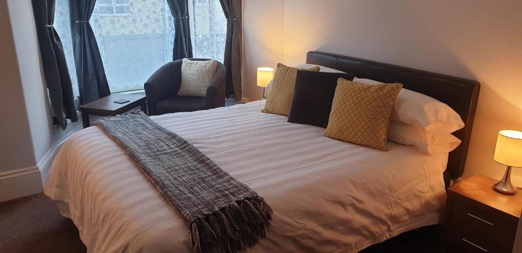 a bedroom with a bed with a chair and a window at Lockinbar Holiday Apartments in Tenby