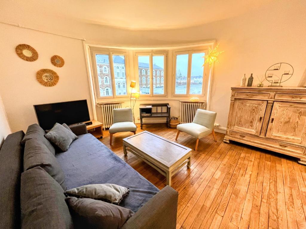 - un salon avec un canapé et une table dans l'établissement Appartement de Charme de 75m², Lumineux et Calme, à Nantes