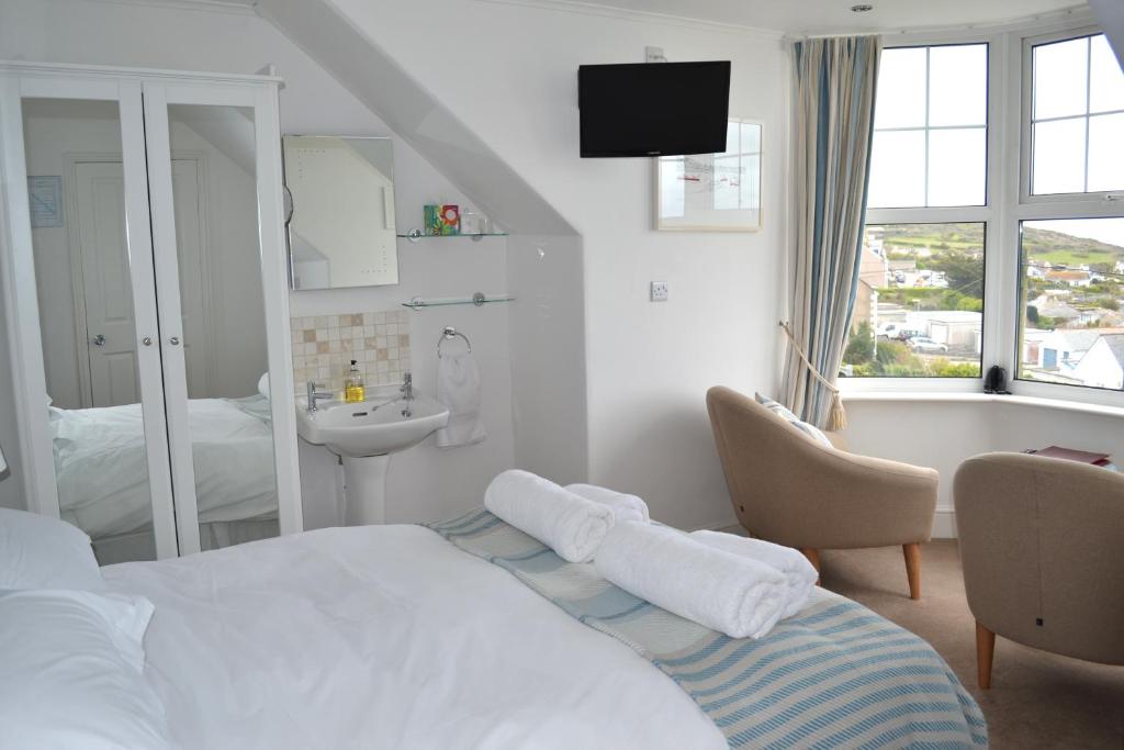 a bedroom with a bed and a sink and a tub at Tregony Guest House in St Ives