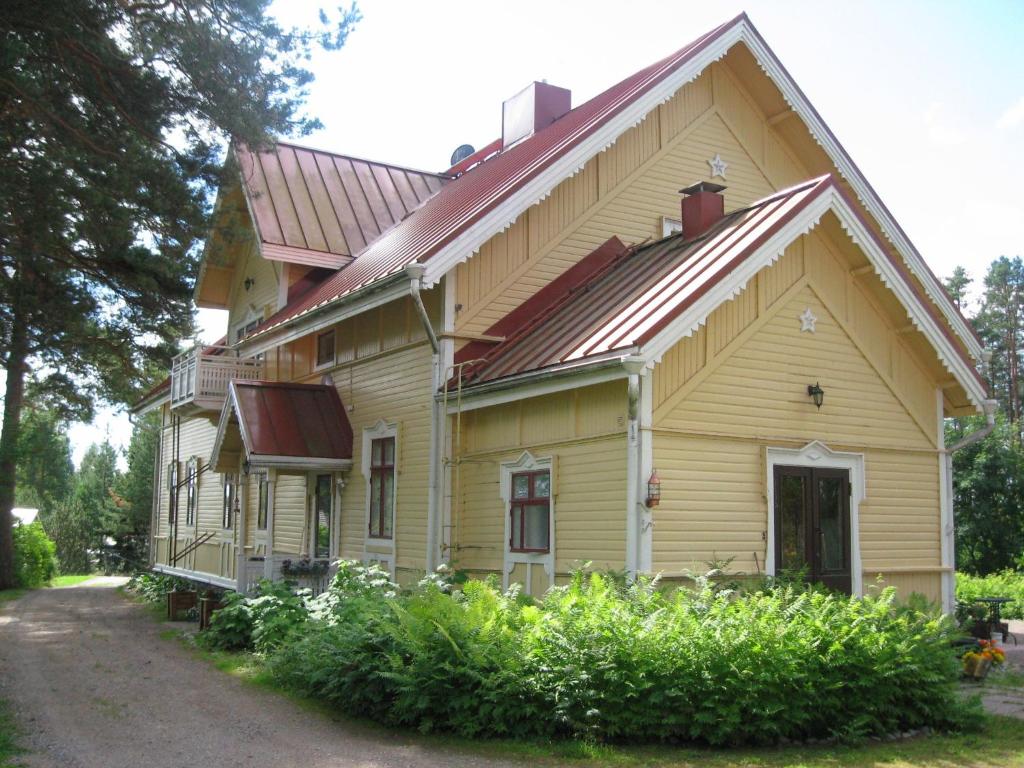una gran casa amarilla con techo rojo en Kivijärven Linnanmäki Apartments, en Kivijärvi