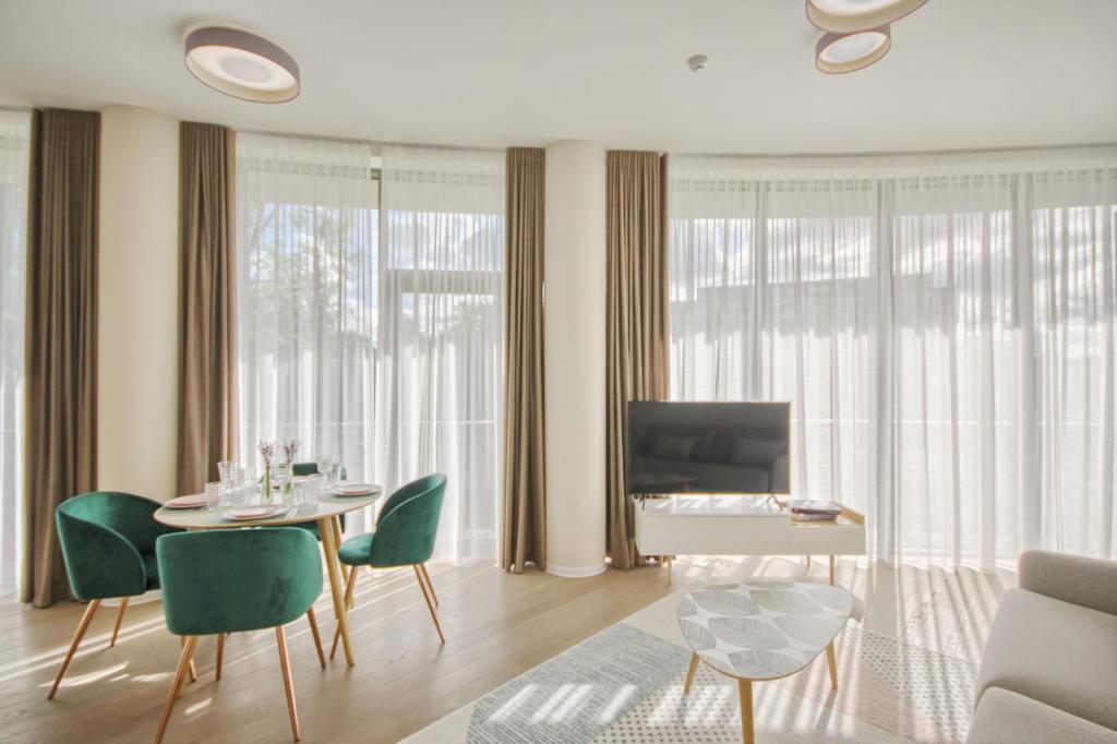 a living room with a table and chairs and a television at Apartment DoMiSol in Druskininkai