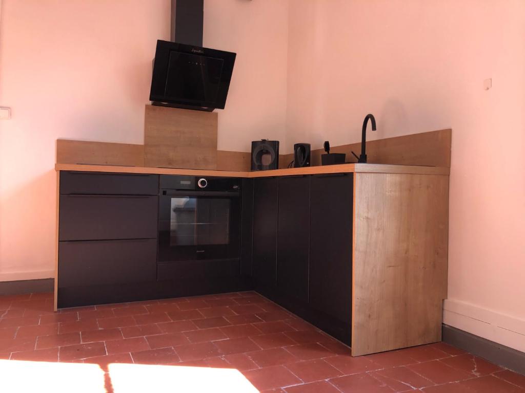 a kitchen with a counter with a tv on top at L&#39;appart du galeriste 85m2 amazing view and space in Béziers