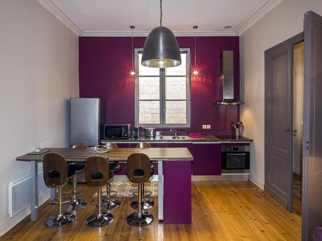 a kitchen with purple walls and a table and chairs at Bord&#39;ôappart Le Cheverus in Bordeaux