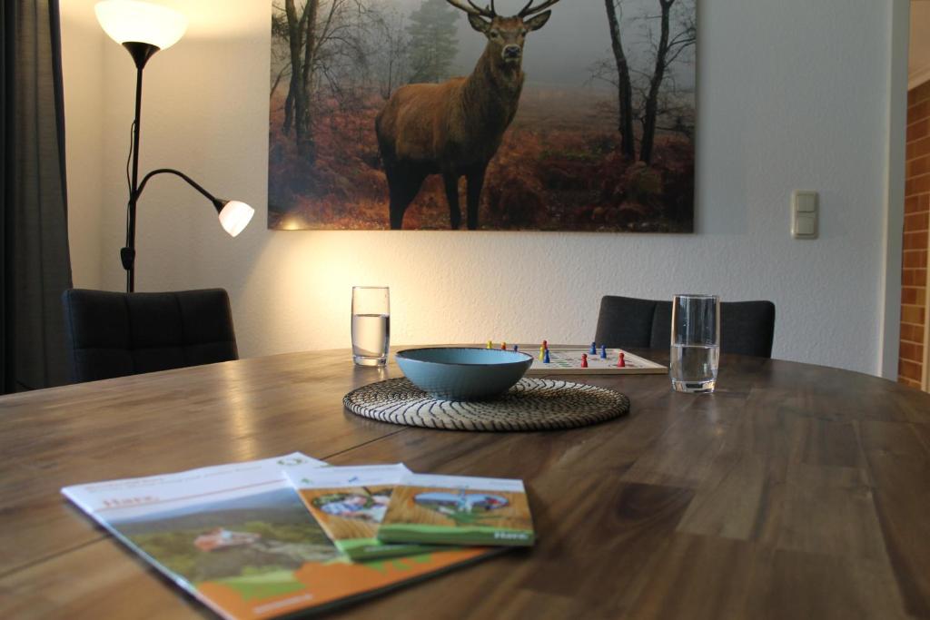 una mesa de madera con un tazón y una foto de un ciervo en Ferienwohnung Jesse, en Braunlage