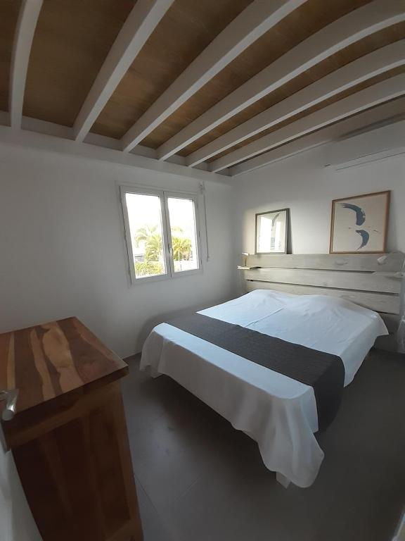 - une chambre avec 2 lits, une table et 2 fenêtres dans l'établissement Appartement neuf a 150 metres de la mer wifi, au Diamant