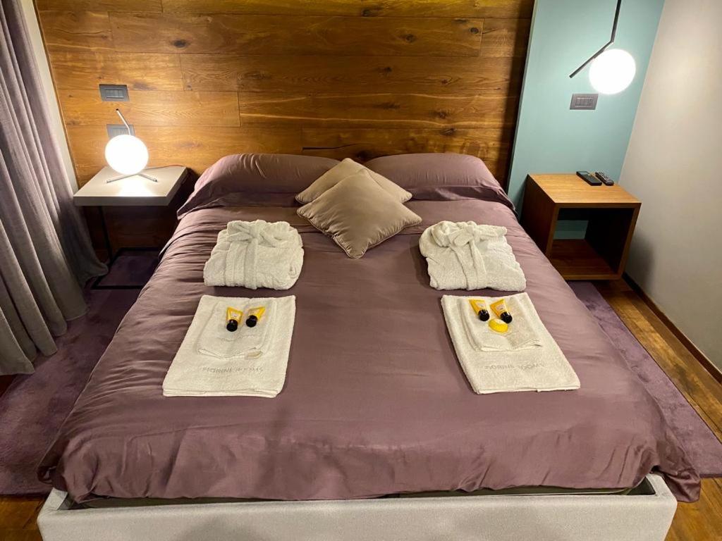 un grande letto con due asciugamani sopra di Fiorini Rooms Pescasseroli a Pescasseroli