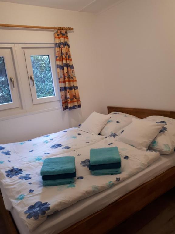 una cama con dos bolsas verdes sentadas en ella en Ferienhaus am Langen See III en Heidesee