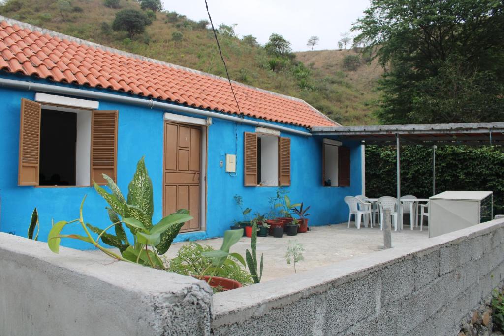 Casa Pé di Polon holiday home في Picos: منزل أزرق أمامه جدار اسمنتي