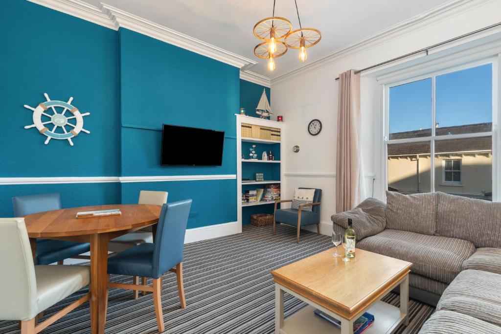 a living room with a couch and a table at Top Sail - Beautiful Apartment, Minutes Walk to Beach and Town Centre in Tenby