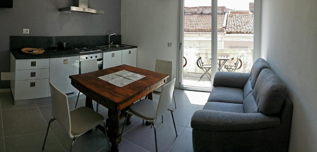 eine Küche mit einem Tisch und einem Sofa sowie einem Tisch und Stühlen in der Unterkunft Josso House in Sorso