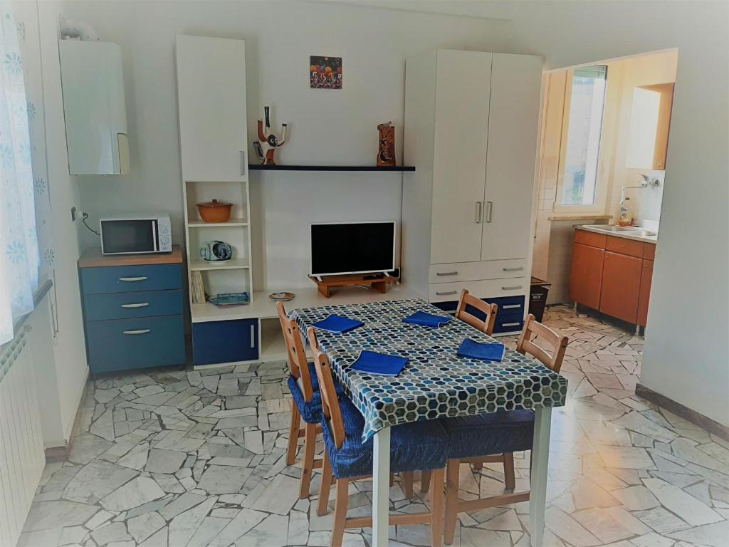 a kitchen with a table with chairs and a television at Casa Stella Marina in Albisola Superiore
