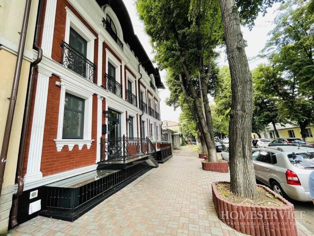 a brick sidewalk next to a building with a tree at Premier City Apart Hotel Chisinau in Chişinău