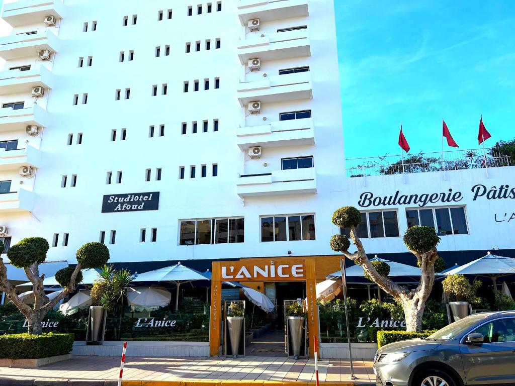 a building with a car parked in front of it at Studiotel Afoud in Agadir